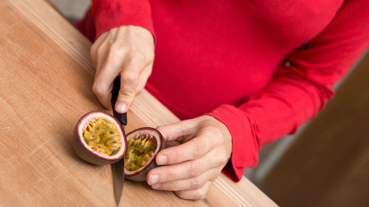 Pregnant women cutting a Purple Passion Fruit because of the positive impact of passion fruit during pregnancy